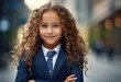 © Natalia - A young girl in a suit and tie standing in the city. Generative AI.
