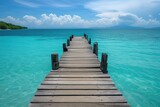 Fototapeta  - a wooden dock leading out to a clear blue sea