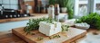 © yusufadi - Tasty white feta cheese and herbs rosemary on cutting board in table at kitchen. AI generated image