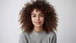 © john - Waist up shot of pleased curly haired woman looks directly at camera has satisfied expression dressed in casual basic jumper isolated over white background