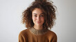 Waist up shot of pleased curly haired woman looks directly at camera has satisfied expression dressed in casual basic jumper isolated over white background