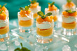 Homemade Greek yogurt with fresh mango slices, in small glass cups, fresh and delicious desserts in individual portions on the table, in soft cyan and orange tones.