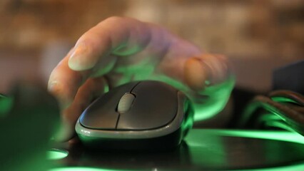 Close-up of a man's hand using a computer mouse while working on a laptop