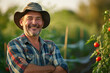 Portrait of mature male farmer wearing hat smiling with folded hands on blurred background of tomato field under bright sunlight