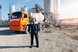 © Parilov - Portrait happy worker of concrete factory, young man in uniform with hard hat on background cement mixer truck