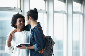 Wall Mural - Couple, hug and students with a book, education and conversation for research and embrace. College, man and woman with ideas or brainstorming with planning and teamwork with knowledge and learning