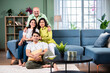 © StockImageFactory - Portrait of happy Indian family of four sitting in modern living room