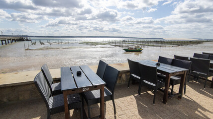 Wall Mural - bar restaurant tables on the tip of Cap Ferret at low tide with oyster farm in Lege in Gironde france