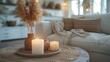 Cozy Home Vignette with Candles, tranquil corner of a modern home, with lit candles on a woven tray, pampas grass, and a plush sofa in the background