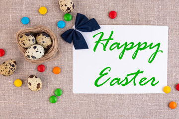 Traditional easter nest with eggs on a linen surface. White card for an inscription.