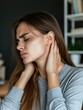 © mariiaplo - Young adult woman holding her neck in discomfort.