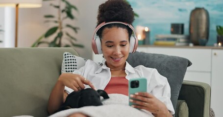 Wall Mural - Happy woman, phone and headphones with dog on sofa in relax for listening to music or audio streaming at home. Young female person with smile, animal or pet on mobile smartphone for podcast at house