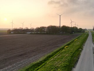 Wall Mural - Aerial shot of a highway road in front of a series of wind turbines