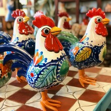 AI-generated Illustration Of Ornate Ceramic Rooster Figurines Arranged Atop A Checkered Table.
