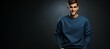 © Wirestock - Portrait of a handsome young man in a blue sweater standing on a dark background, AI-generated.