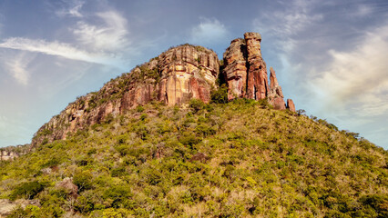 Poster - Stunning, sun-drenched landscape featuring rocky terrain and lush green shrubbery