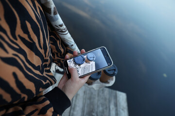 aesthetic photo. a cup of coffee in the hands of a girl. take pictures of coffee on a mobile phone