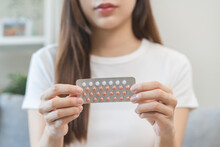 Contraception and pregnancy, menstruation concept, birth control pills asian young woman hand holding hormonal oral contraceptive medicine, take pharmaceutical to prevention, safe virus sex disease.