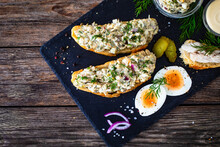 Tasty Sandwich With Egg Salad And Smoked Mackerel On Wooden Table
