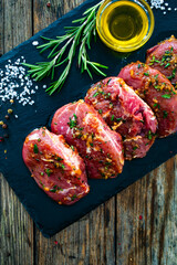 Wall Mural - Raw pickled pork cheeks on stony cutting board on wooden table
