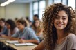Curly-haired female college student smiling and looking at camera in classroom, with copy space
