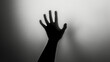 © Vladimir - Hand silhouette on grey background. Blurred human hand shape out of focus