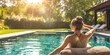 Woman sunbathing by the swimming pool in the backyard