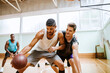 © Marko Geber - Basketball players playing basketball in an indoor basketball gym