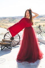 A girl in a flying dress on the roof of a house on ancient city background