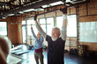 © Davor - Senior man and woman exercising in gym doing pull-ups