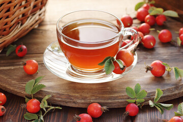 Canvas Print - Rosehip tea with fresh red dog-rose berries on wooden table, closeup, copy space, vitamin supplement drink, face skin care, beauty healthy treatment concept