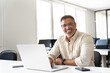 © Stock 4 You - Portrait of mature Indian or Latin business man ceo trader using laptop computer, typing, working in office. Middle-age Hispanic smiling handsome businessman entrepreneur looking at camera. Copy space