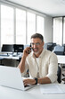 © Stock 4 You - Middle aged Latin or Indian businessman having call on smartphone with business partners or clients. Smiling mature Hispanic man sitting at table talking by mobile cellphone in office, vertical.