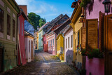 Fototapeta Uliczki - Uphill view on empty Sighisoara street with colorful medieval houses, Romania