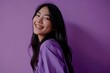 Portrait of a beautiful young asian woman smiling on purple background