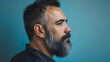© Nemanja - Handsome and good looking middle aged man in his 40s or 50s with gray beard and hair. Side view closeup studio photography, blue wall background, neutral and serious face expression