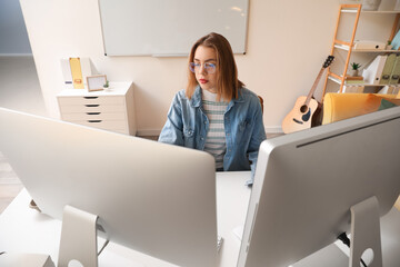 Female programmer working with computer at table in office