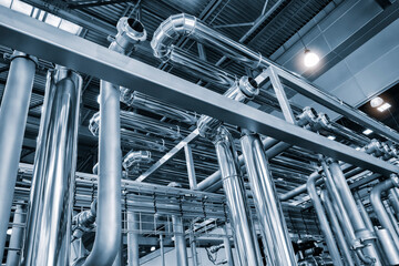 Poster - Metal pipes and containers in an industrial building, view from bottom to top. Industrial concept background