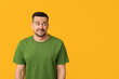 Handsome ashamed young man on yellow background