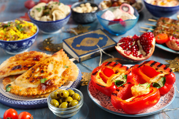 Wall Mural - Traditional Eastern dishes and Koran on blue wooden table. Ramadan celebration