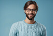 Young handsome man with beard wearing casual sweater and glasses over blue background