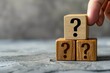 Meaning of a wooden cube block with a question mark on a table with a row of wooden blocks with question marks Answer FAQ info