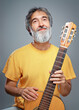 © luengo_ua - Aged man with a guitar on grey background