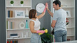 Beautiful couple cleaning shelving high five at home