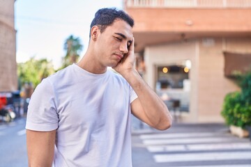 Sticker - Young hispanic man stressed suffering for headache at street