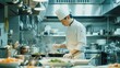 © logonv - A master chef intently focuses on perfecting a dish in a busy professional kitchen, ideal for culinary excellence and gastronomy storytelling.