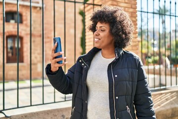 Poster - African american woman smiling confident having video call at street