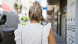© Krakenimages.com - Young blonde woman standing backwards at street