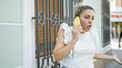 © Krakenimages.com - Young blonde woman arguing on smartphone with serious expression at street