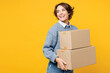 © ViDi Studio - Young smiling cheerful woman wears grey knitted sweater shirt casual clothes hold cardboard boxes look aside on area workspace isolated on plain yellow background studio portrait. Lifestyle concept.